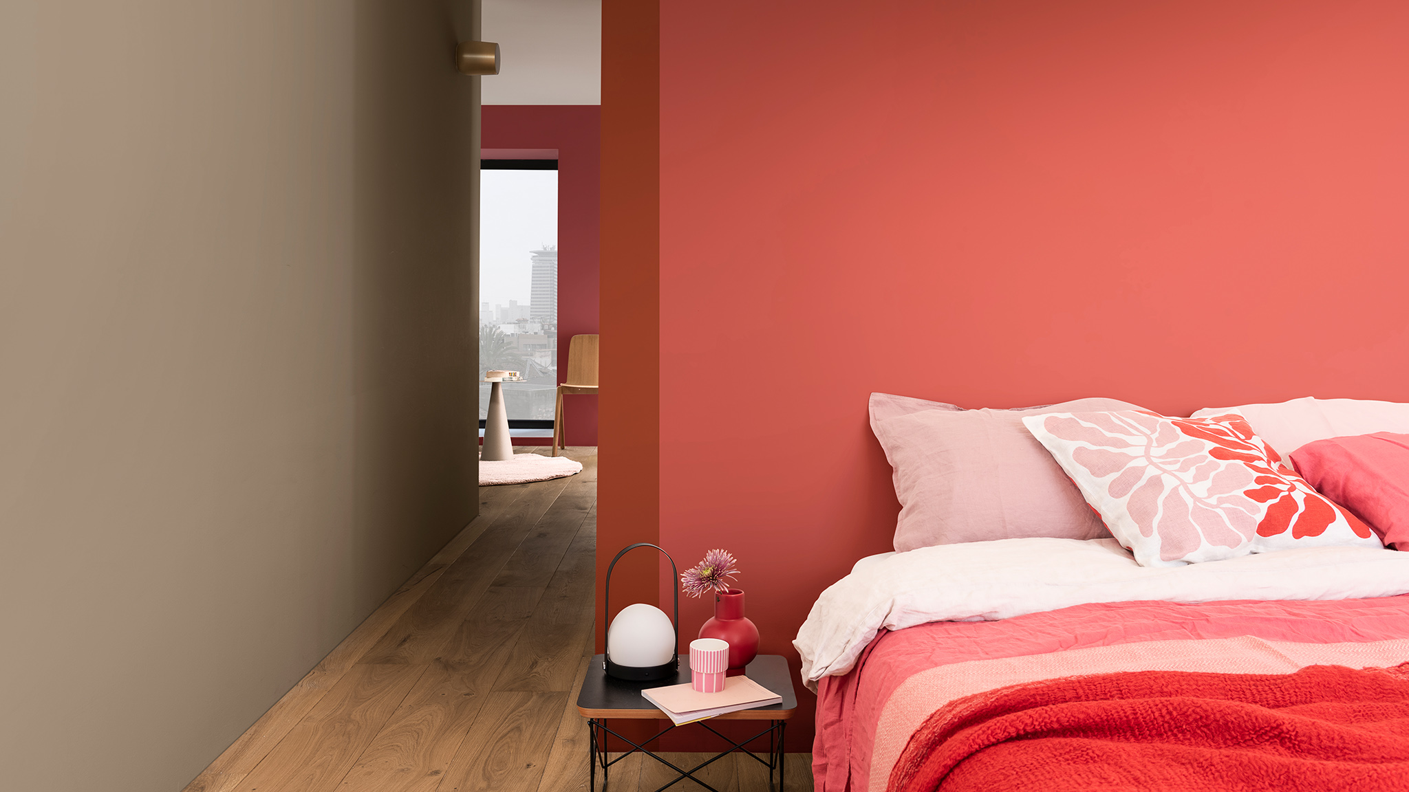 Tempat tidur dihias dengan bantal seperti warna bunga dipadukan dengan dinding merah muda gelap